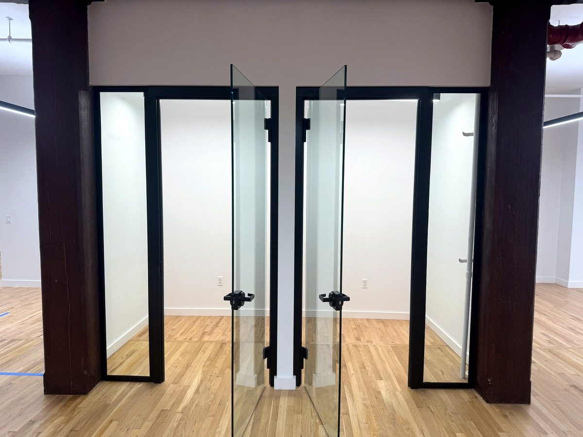 Two glass phone booths between timber columns, partial 3rd floor at 131-133 Spring Street
