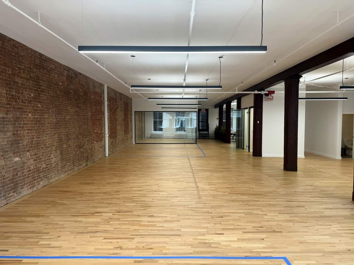 Long hardwood floor along exposed brick wall, partial 3rd floor at 131-133 Spring Street