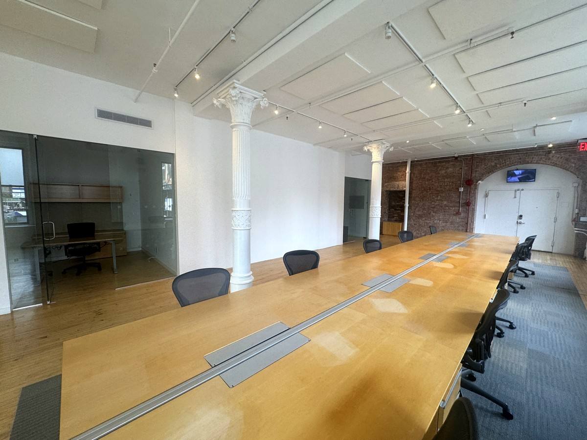 Open work area with exposed brick arch, 2nd floor at 380 Lafayette Street
