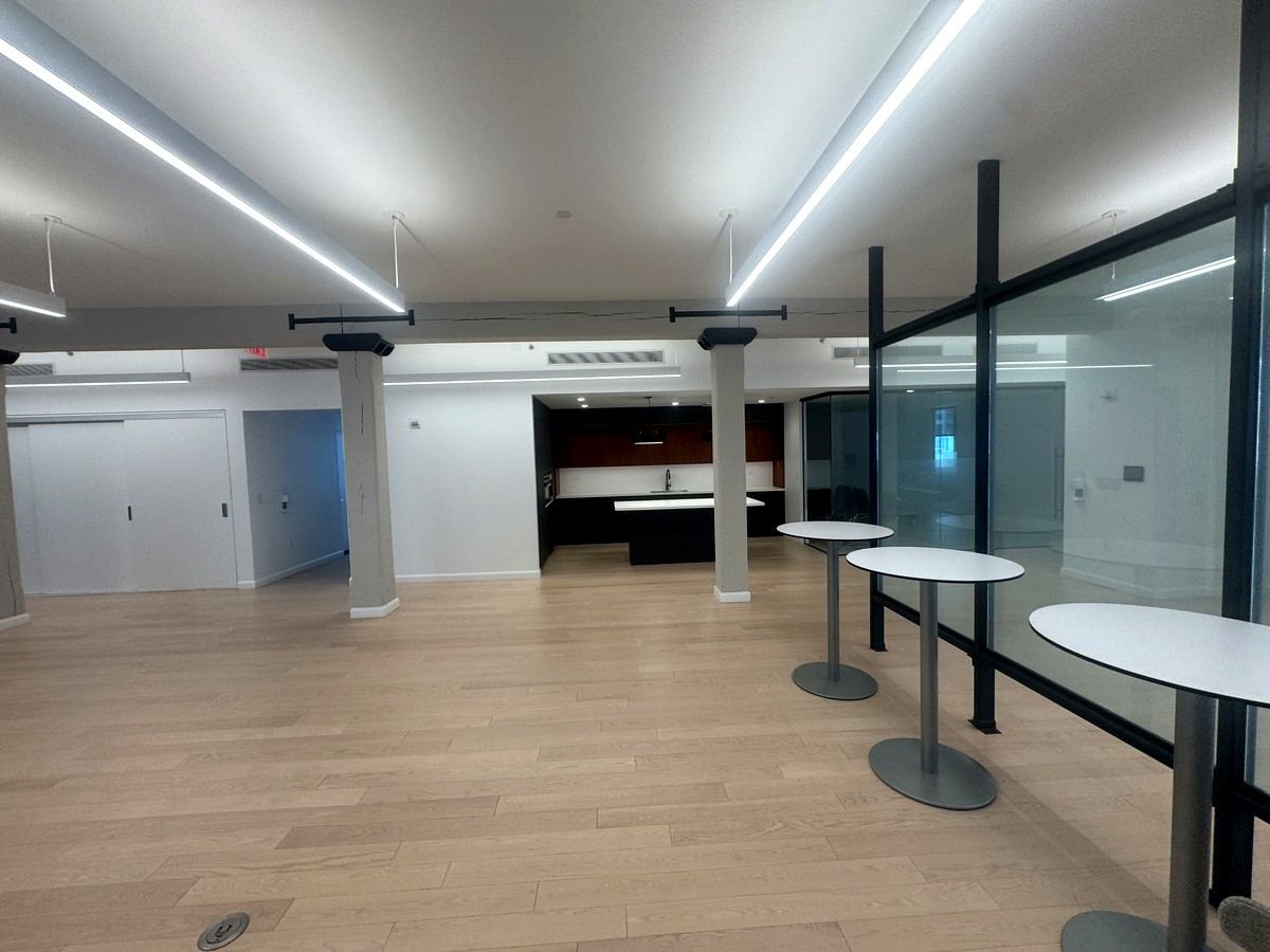 Café tables beside pantry with island and glass room, 5th floor at 530 West 25th Street