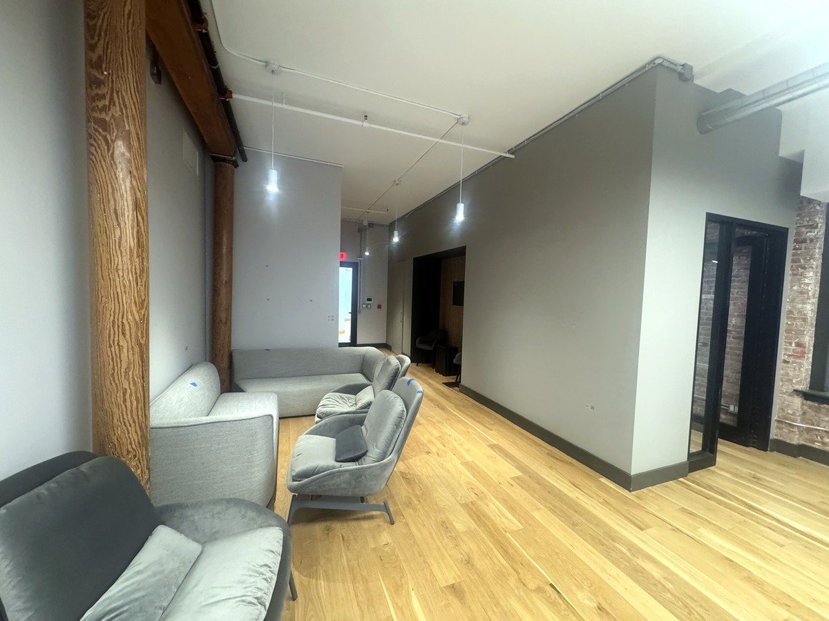 Lounge area with gray sofas and exposed timber columns at 46 Greene Street