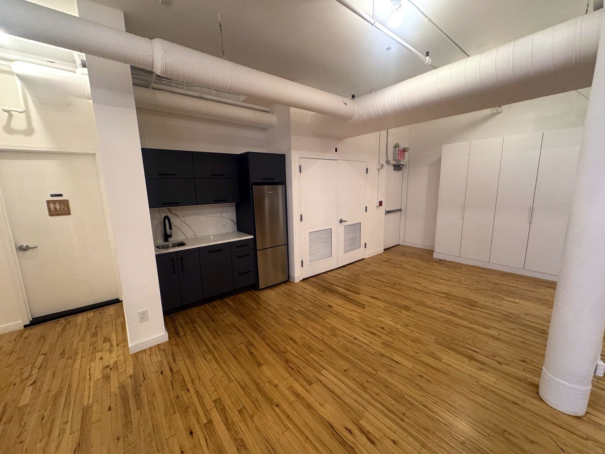 Open loft office with dark cabinetry pantry and hardwood floors at 46 Greene Street