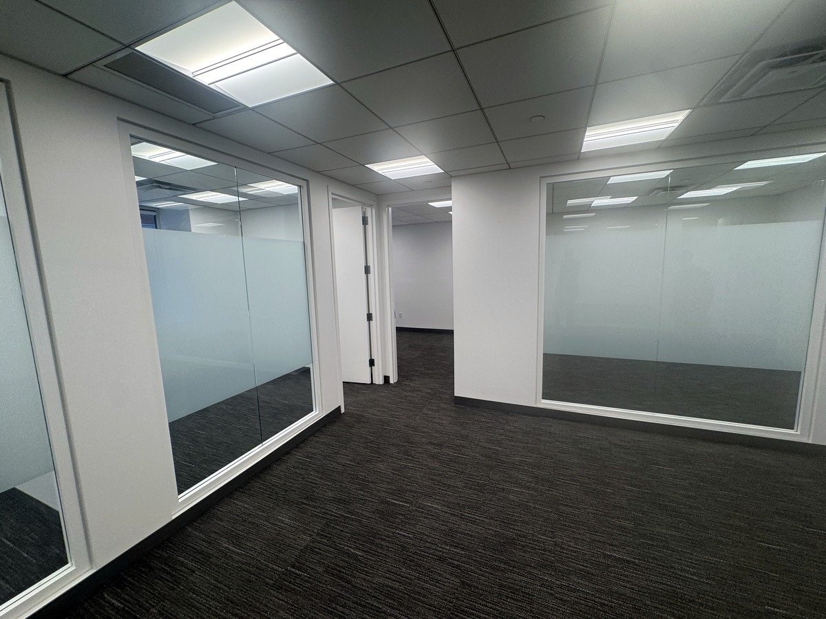 Open carpeted area with frosted glass offices, 12th floor at 20 West 55th Street