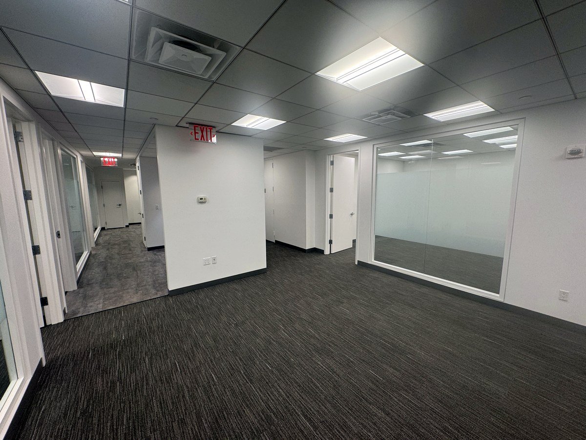 Open area with glass-walled offices and corridor, 12th floor at 20 West 55th Street