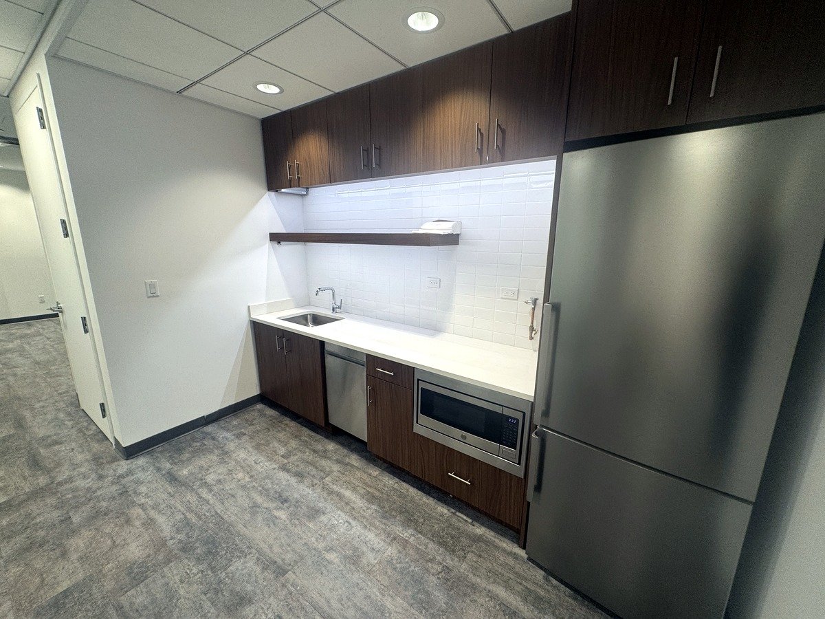 Pantry with wood cabinets and stainless fridge, 12th floor at 20 West 55th Street